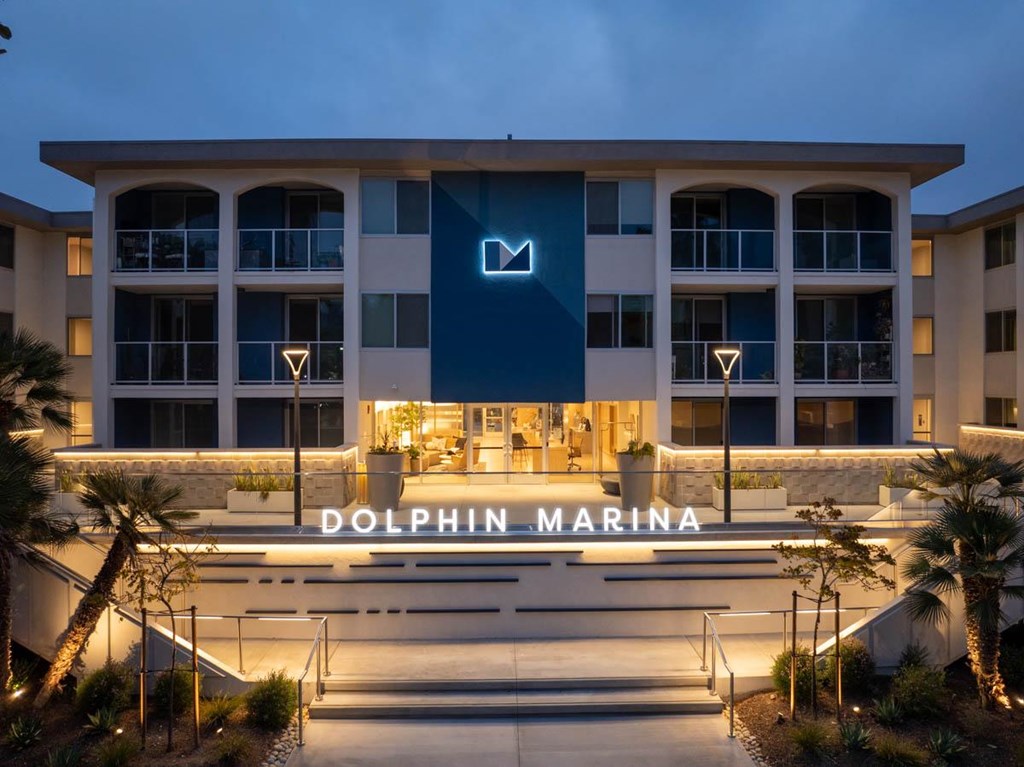Dolphin Marina building with a dark blue signboard and lights on.