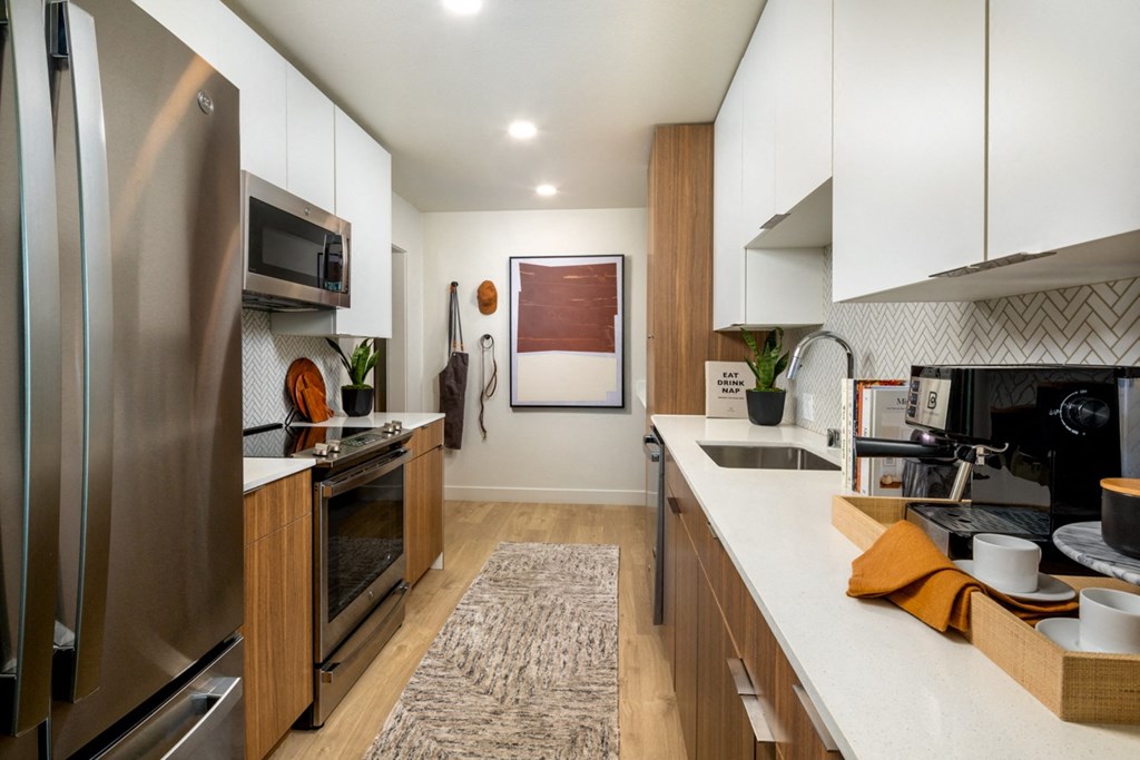 A modern kitchen with stainless steel appliances and wooden cabinets.