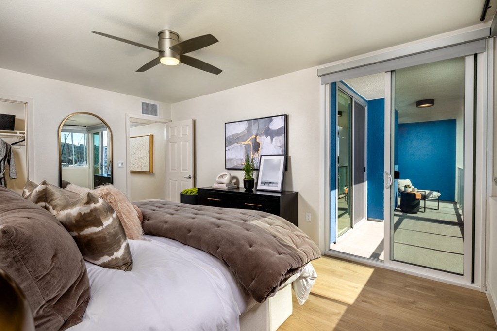 A bedroom with a bed, dresser, and mirror.