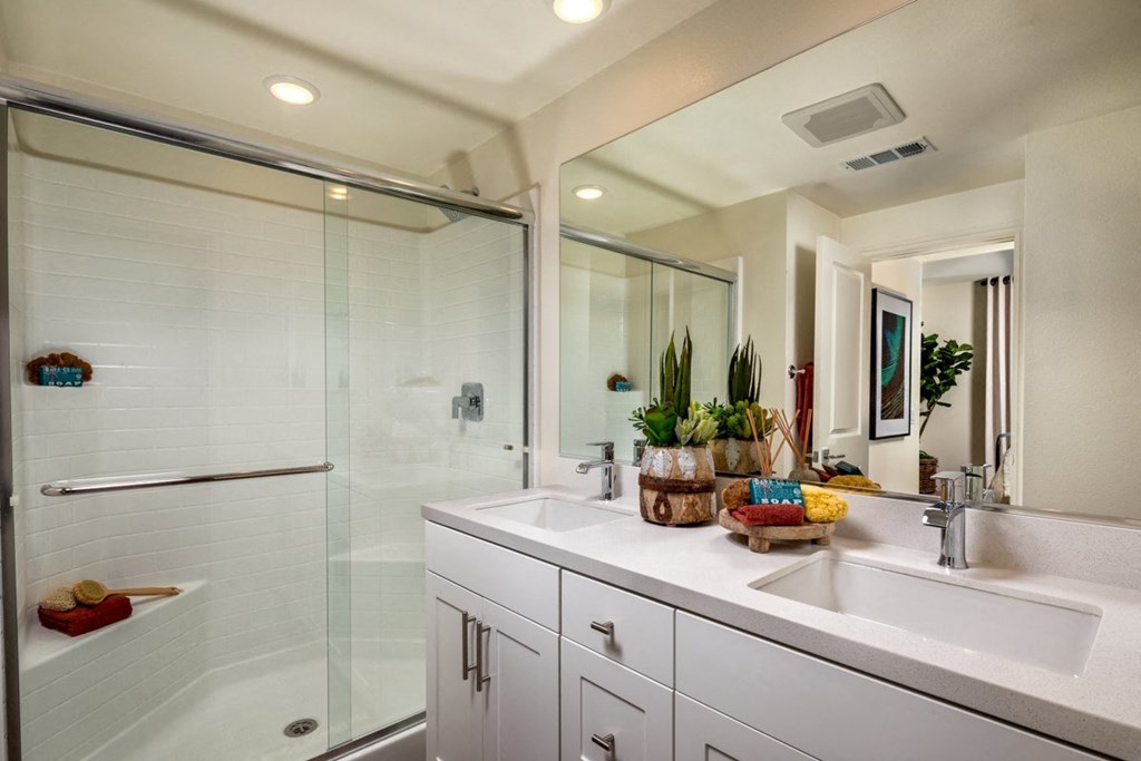 a bathroom with two sinks and a shower