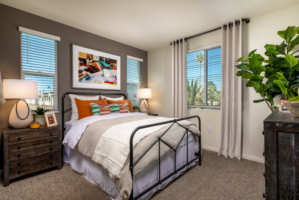 a bedroom with a bed and two windows