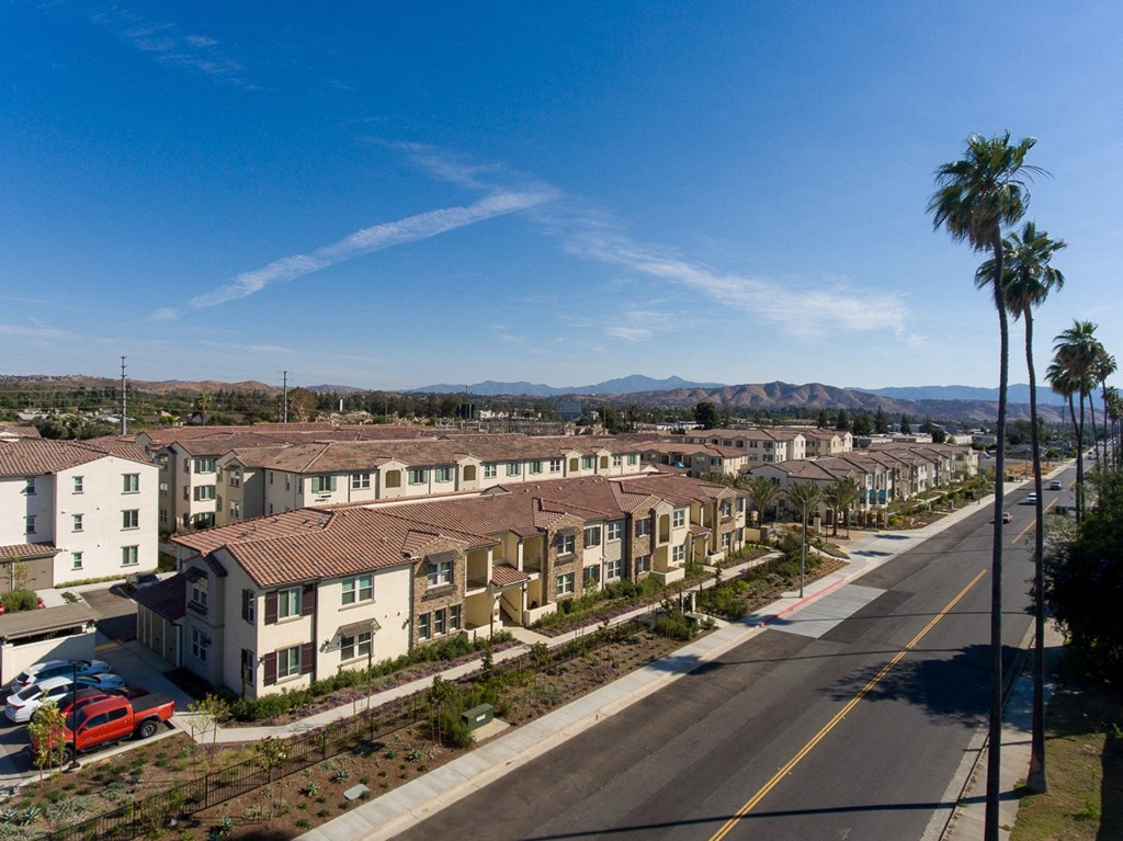 an aerial view of a neighborhood with a street and mountains in the background