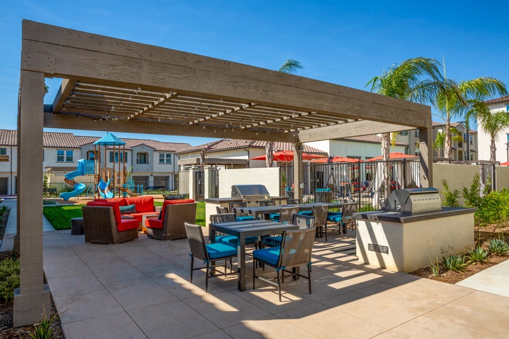 an outdoor patio with tables and chairs and a fountain