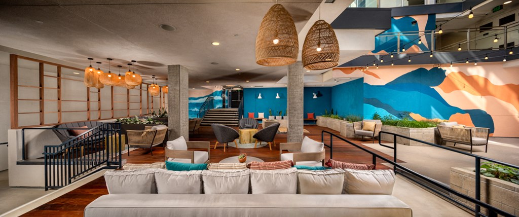 a living room with couches and chairs and a mountain mural on the wall