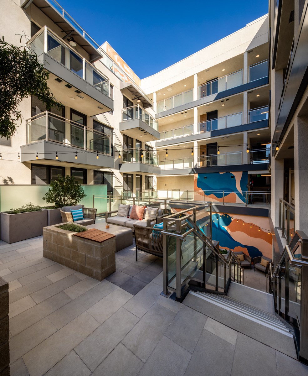 a communal area with a couch and a table in front of an apartment building