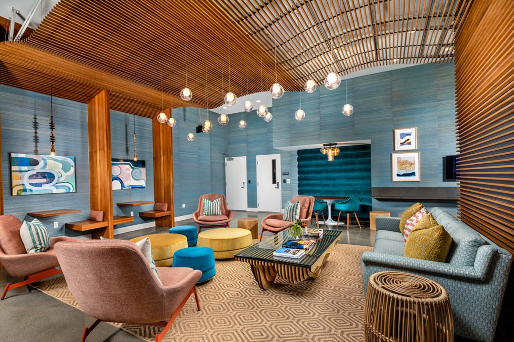 a living room with blue walls and a wooden ceiling and furniture