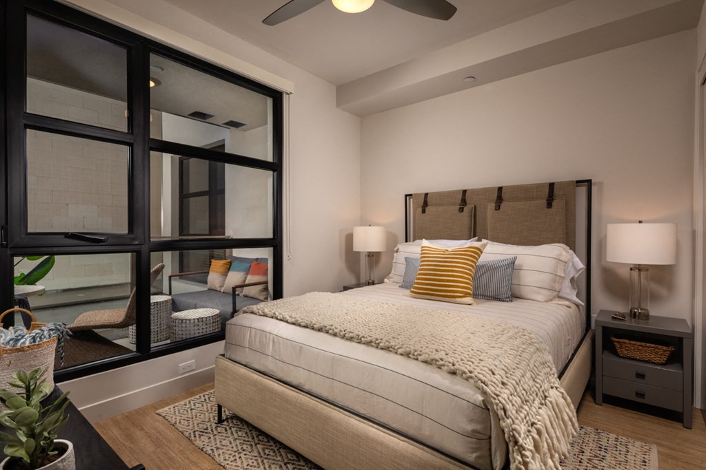 a bedroom with a large window and a bed