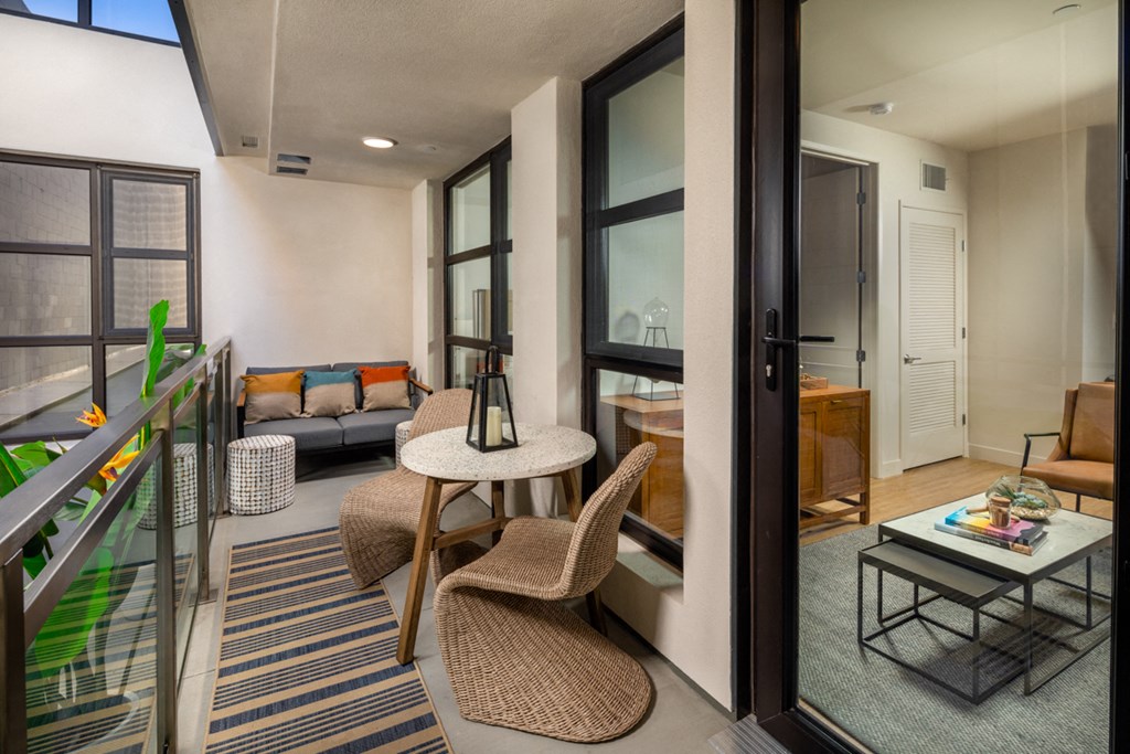a living room with a table and chairs and a balcony