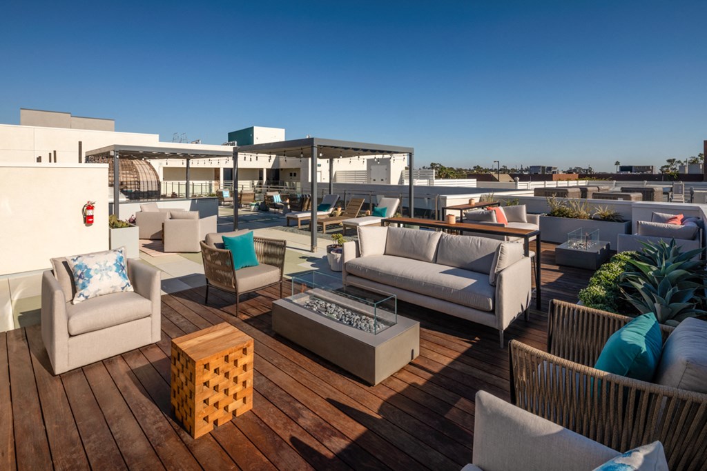 a roof top patio with couches and chairs and a table