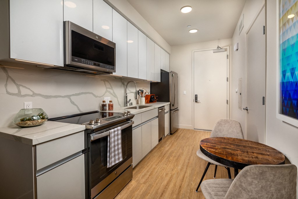 a kitchen with white cabinets and stainless steel appliances and a microwave