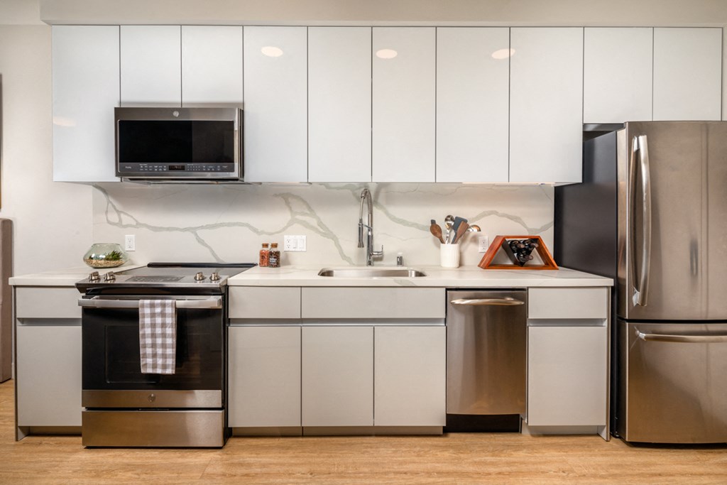 a white kitchen with stainless steel appliances and white cabinets