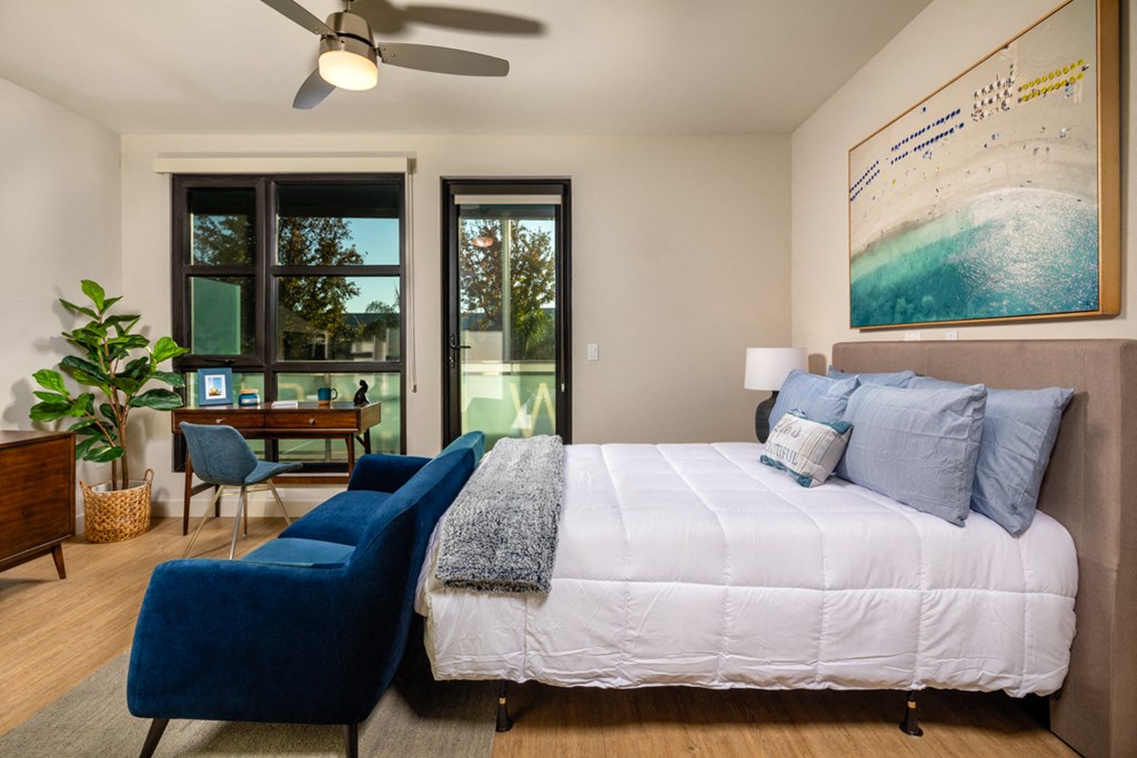 a bedroom with a large bed and a blue chair
