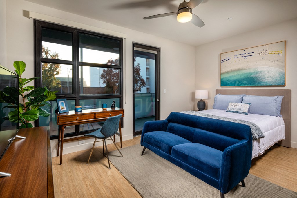 a bedroom with a bed and a desk with a chair