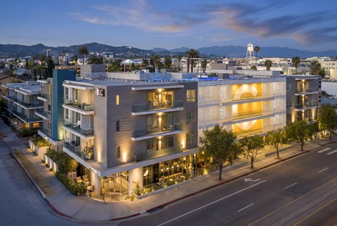 A modern building with a large glass window and a white logo on the side.