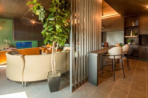 A modern living room with a curved sofa and a dining area with chairs.