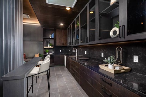 A modern kitchen with dark wood cabinets and a marble countertop.