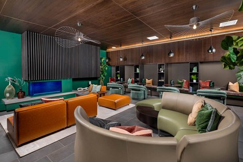 A living room with a green wall and a brown couch.