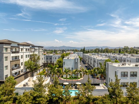 A view of apartment buildings with a pool in the foreground.