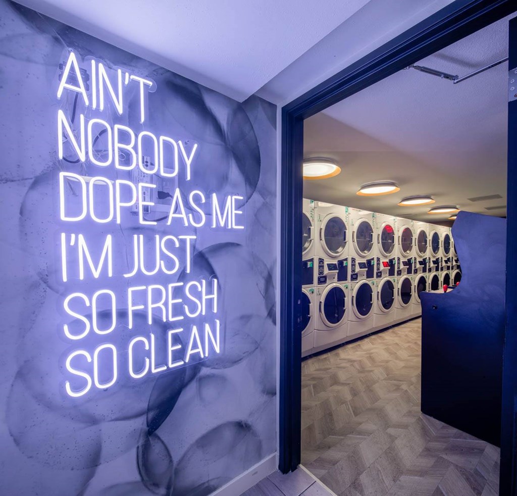 A laundromat with a sign that says "Ain't nobody dope as me I'm just so fresh so clean."