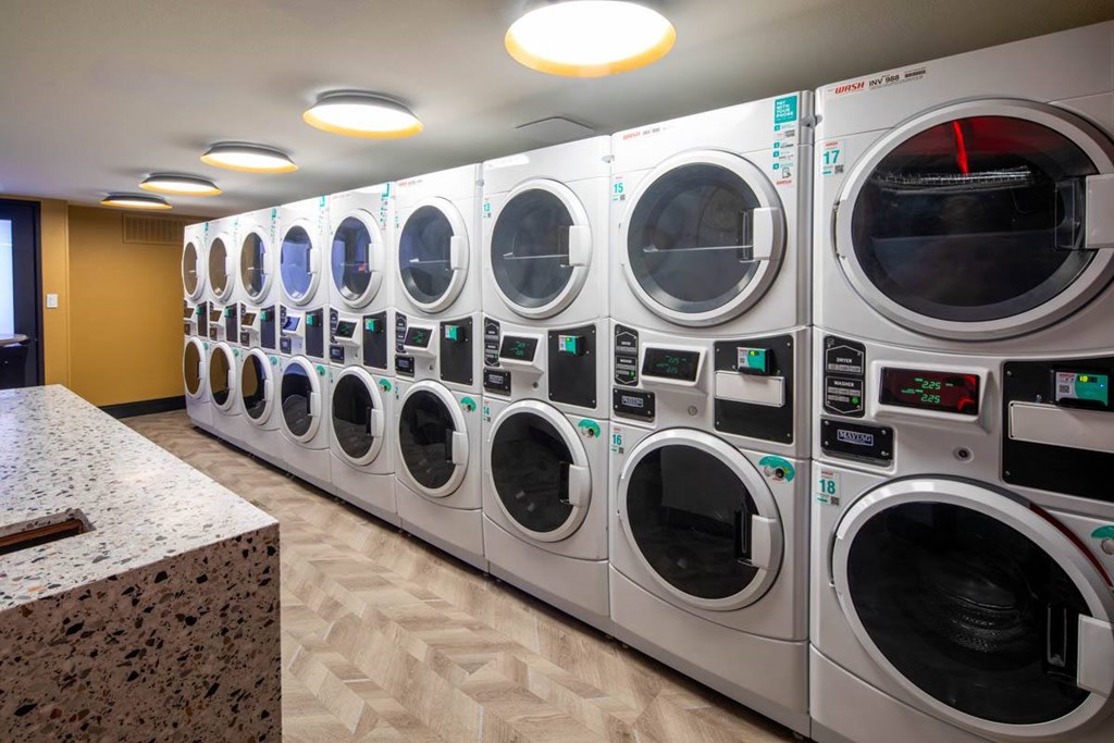 A row of industrial washing machines are lined up in a room.