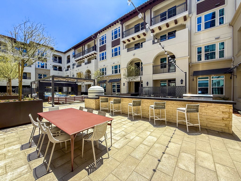 A patio with a table and chairs is in front of a building.