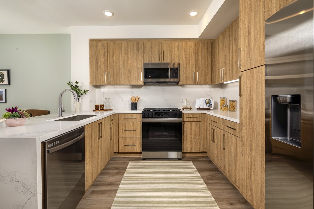 A modern kitchen with wooden cabinets and stainless steel appliances.