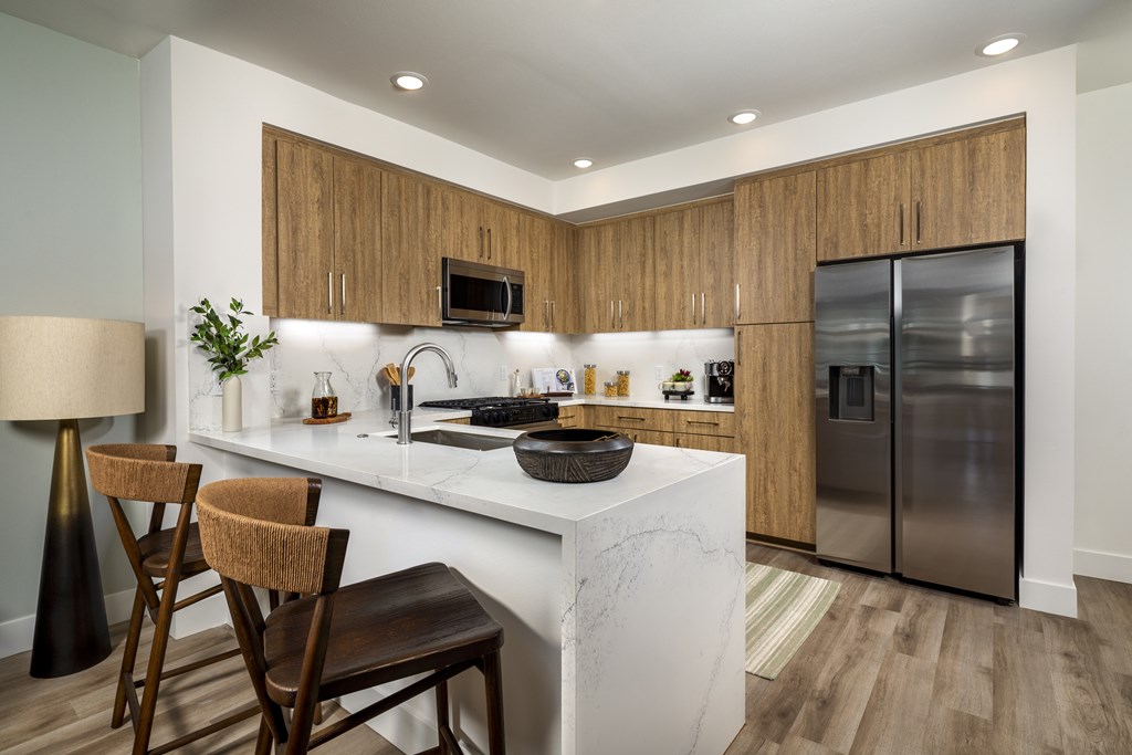 A modern kitchen with a white island and wooden cabinets.