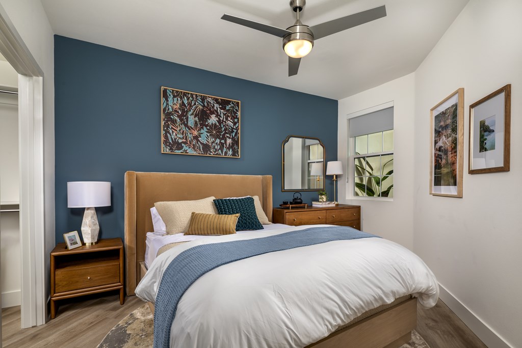 A bedroom with a bed, nightstand, and a ceiling fan.