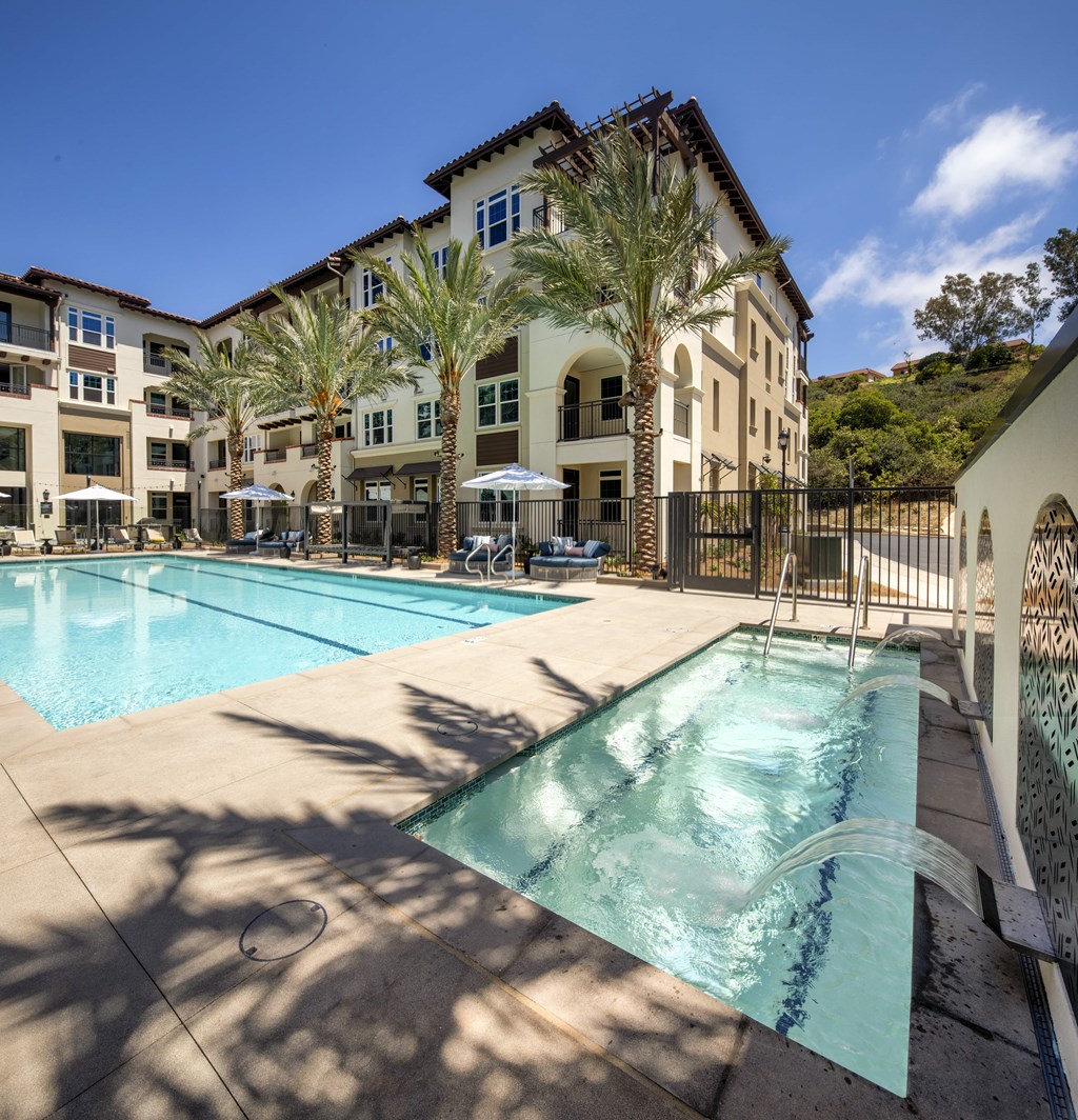 A pool surrounded by palm trees and buildings.