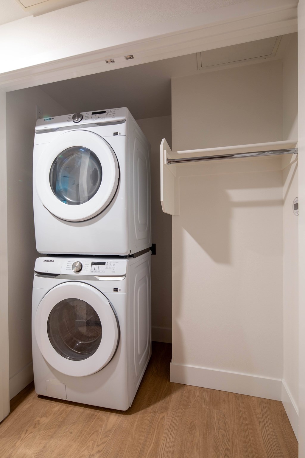 Two white front loading washing machines in a small laundry room.