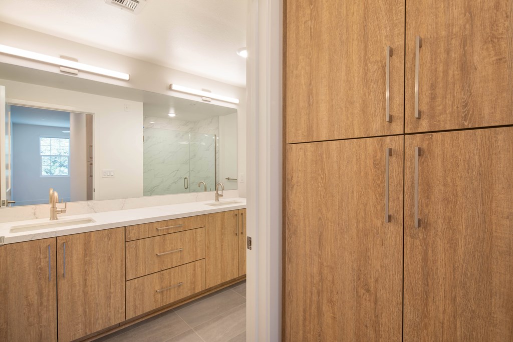 A bathroom with wooden cabinets and a marble counter.
