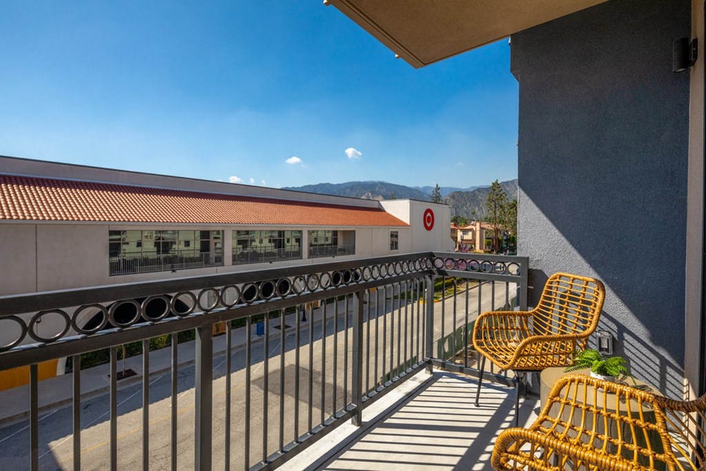 a balcony with yellow chairs and a building in the background