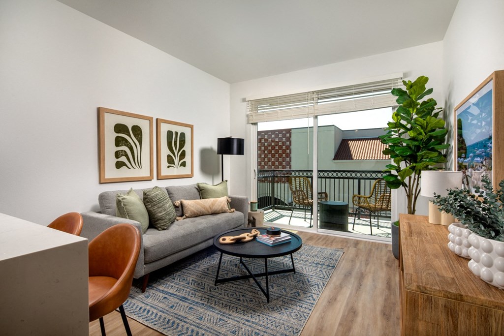 a living room with a couch and a coffee table and a balcony