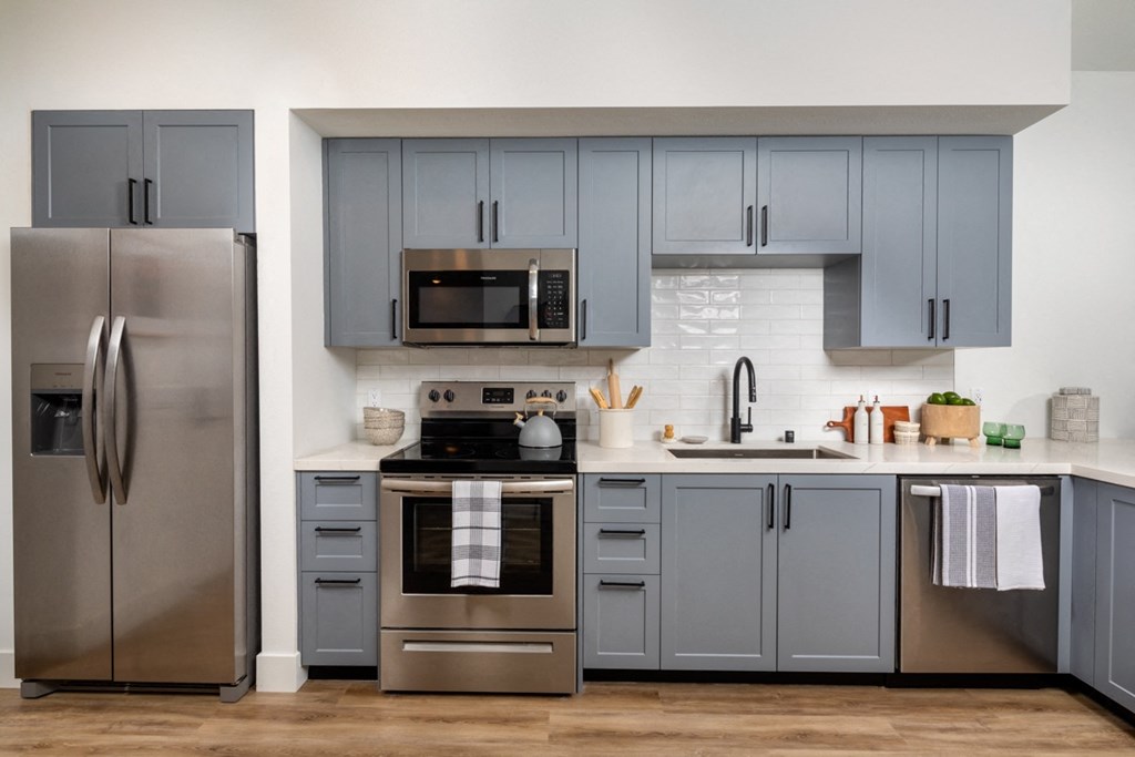 a kitchen with stainless steel appliances and blue cabinets