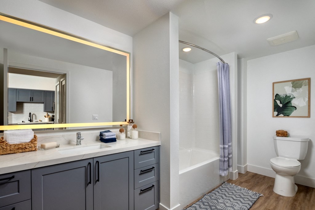 a bathroom with a large mirror and a toilet and a shower