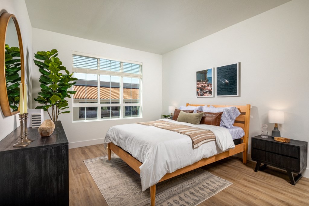 an open bedroom with a bed and a large window