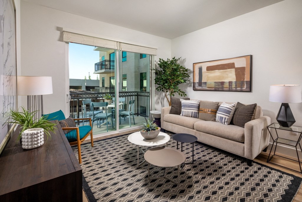 a living room with a couch and a coffee table and a balcony