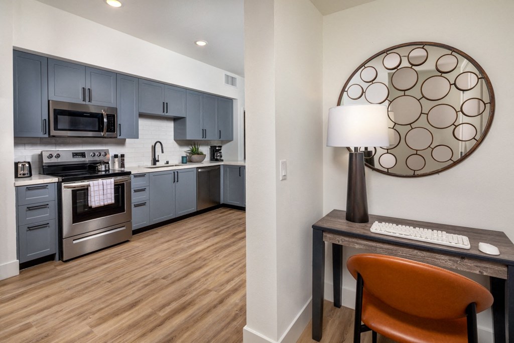 a kitchen with stainless steel appliances and a desk with a chair