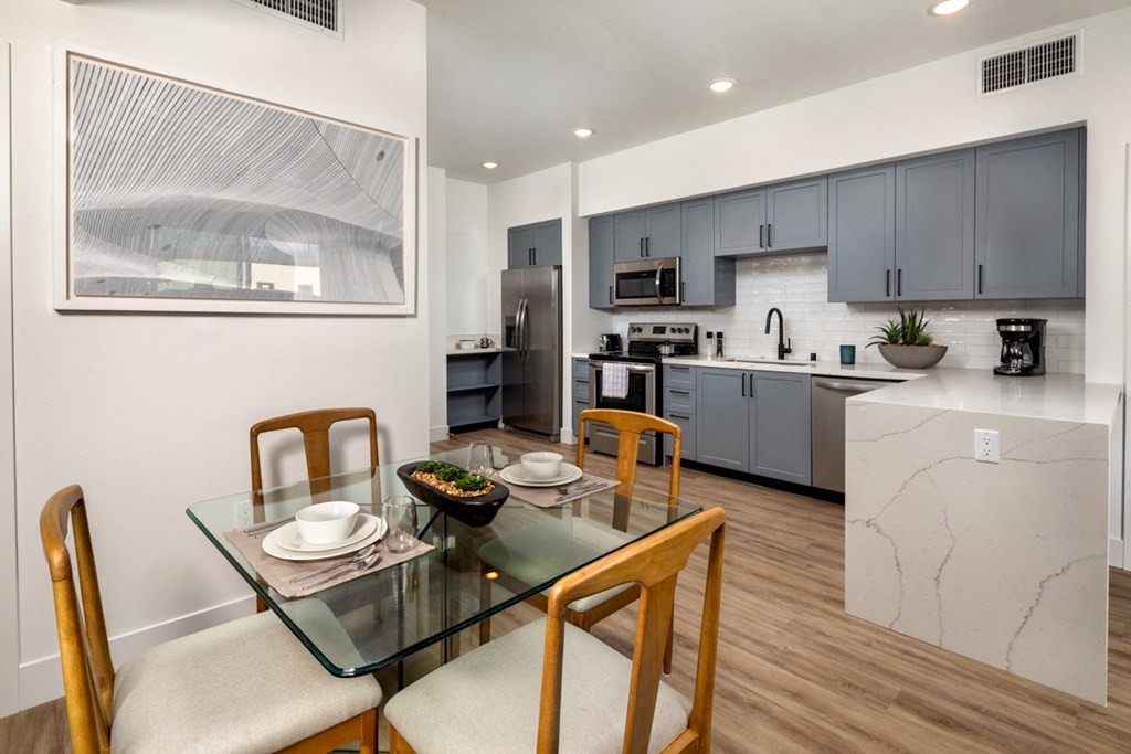 a kitchen and dining room with a glass table and chairs