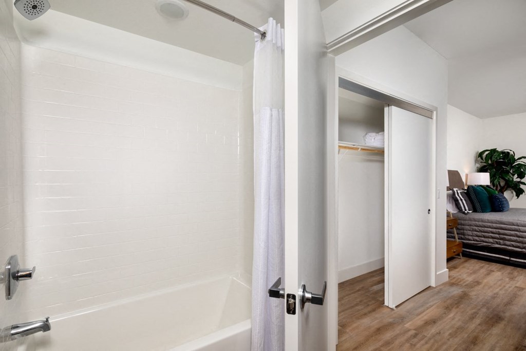 a bathroom with a shower and a door to a bedroom