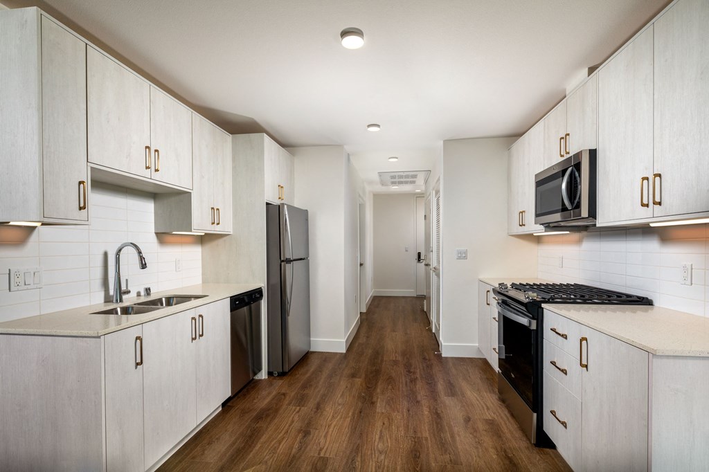 a kitchen with white cabinets and a black stove and a refrigerator