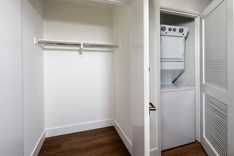an empty room with a refrigerator and a white closet