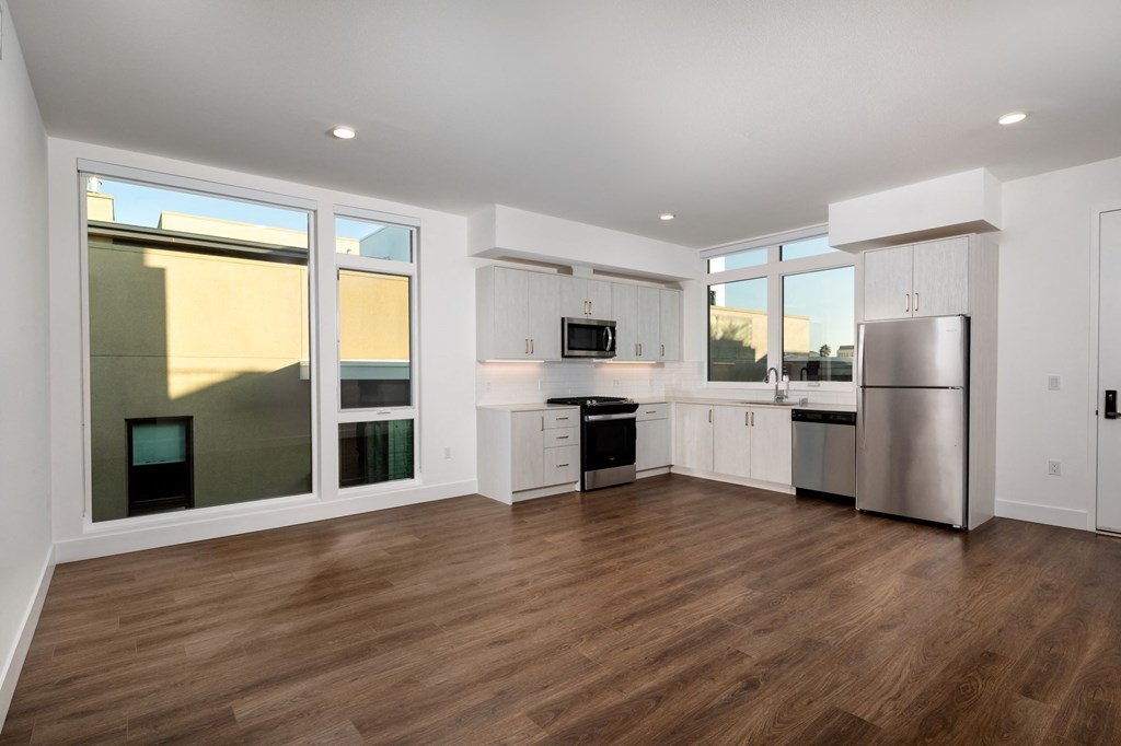 a kitchen with white cabinets and a stainless steel refrigerator