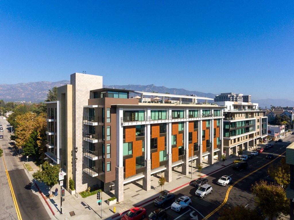 an aerial view of a building with cars parked in front of it