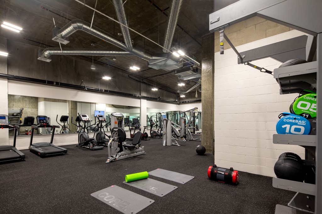 a gym with weights and other exercise equipment in a building with white walls