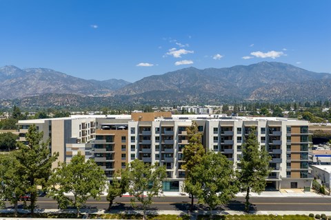 A large building with a mountain range in the background.