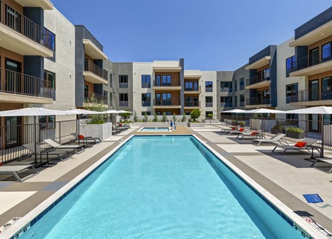 A large swimming pool in front of apartment buildings.