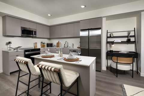 A modern kitchen with a dining table set for two.