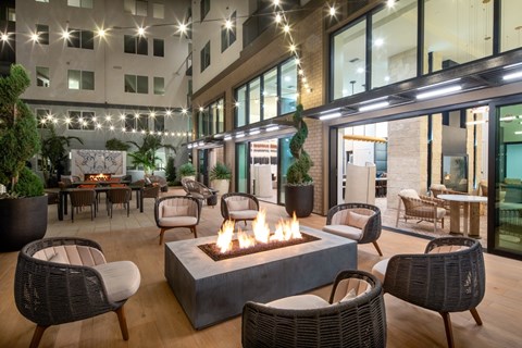a courtyard with a fire pit and chairs and tables