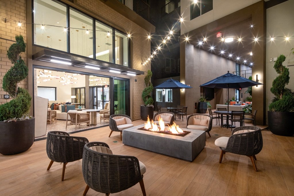 a patio with a fire pit and chairs and tables
